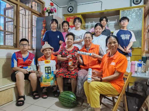 圖2.團隊在社區(qū)老人家中與八桂義工志愿團隊的合影